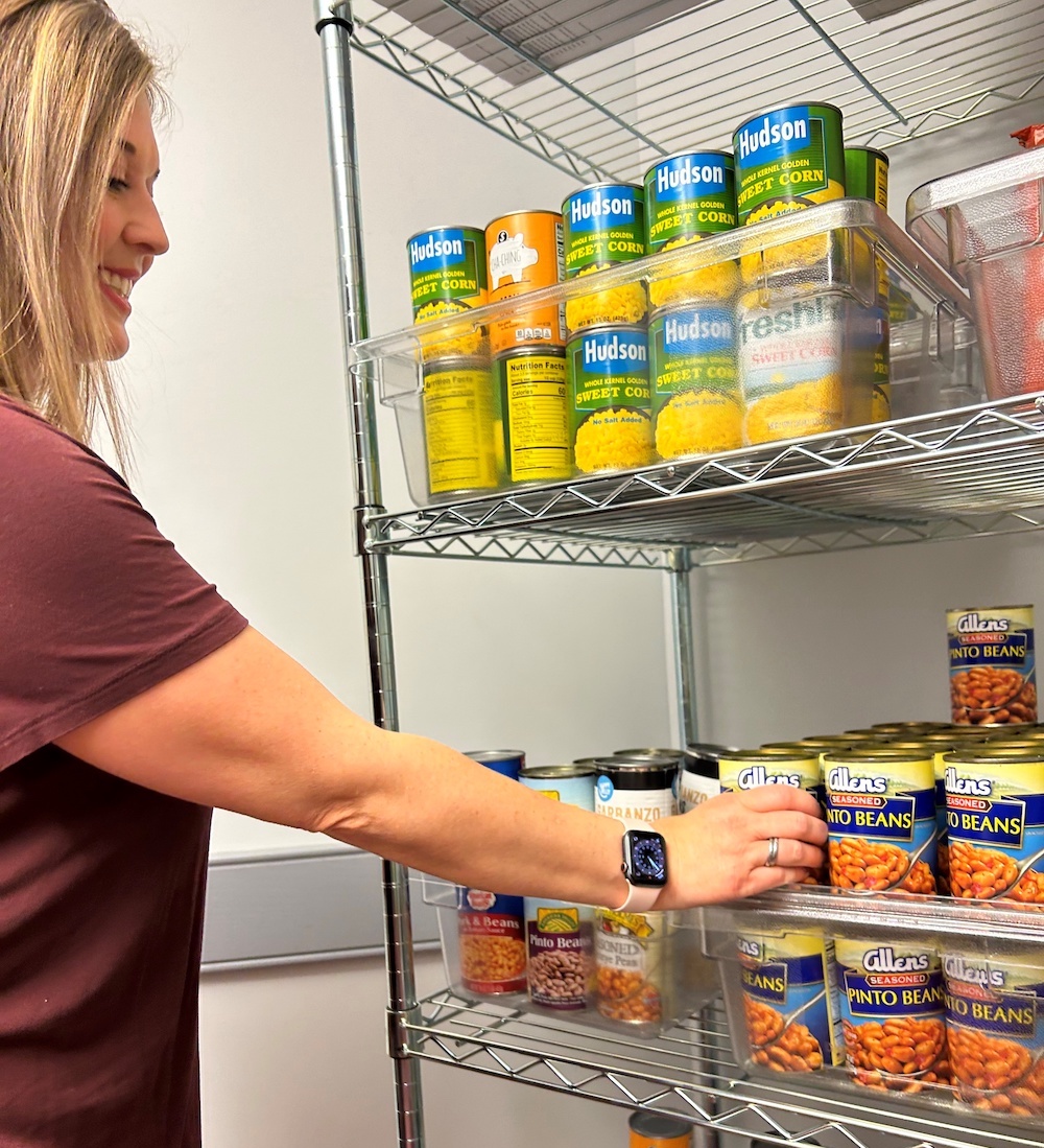 An employee grabbing a can from the Highlander Pantry.