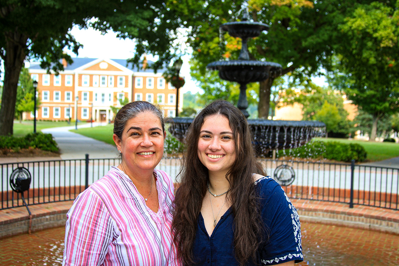 Two people smiling in front of the fountain